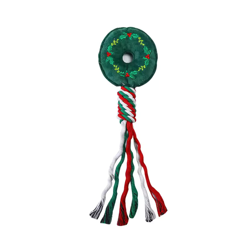 Durable Christmas dog rope toy featuring a green plush wreath top embroidered with red berries and a braided red, white, and green cotton rope handle.