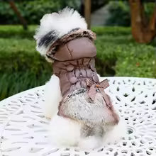 Back view of a small dog in a brown, quilted coat with thick brown faux fur trim and decorative bow tie.