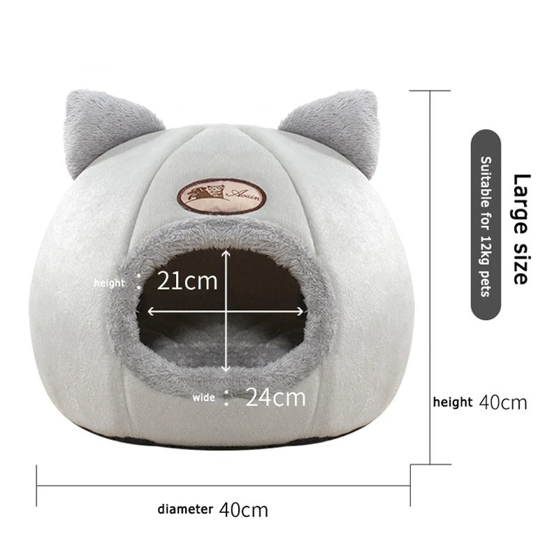 A cat resting comfortably inside the cozy, cold-proof cat head-shaped bed.